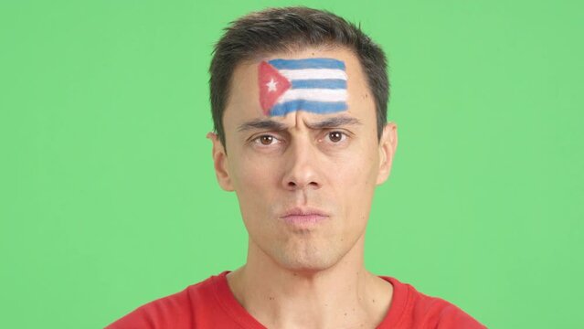 Serious man with a cuban flag painted on the face