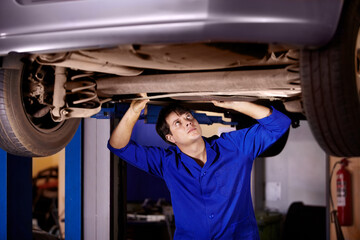 Car, inspection or repair with a mechanic man in a garage for a report on a vehicle service for insurance. Maintenance, professional and a young professional engineer in a workshop for assessment