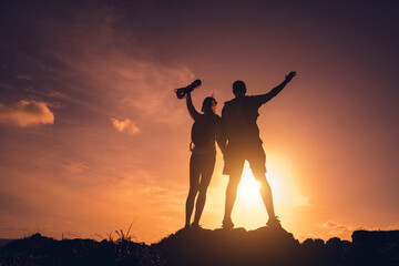 Obraz premium Happy young couple climbs to the top in the mountains near the ocean