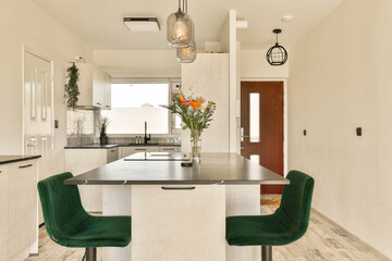 a kitchen with two green chairs and a table in the center of the room, next to it is a sink