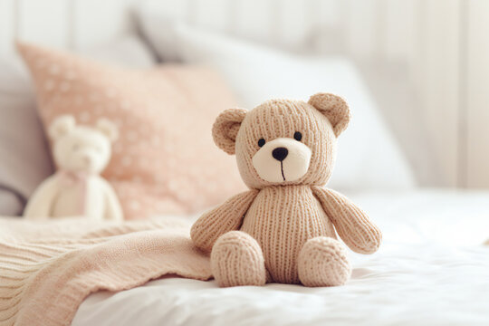 A cute knitted bear on a bed in bedroom