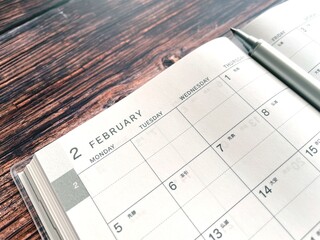 木製テーブルの上で開いて置いた2月のスケジュール帳