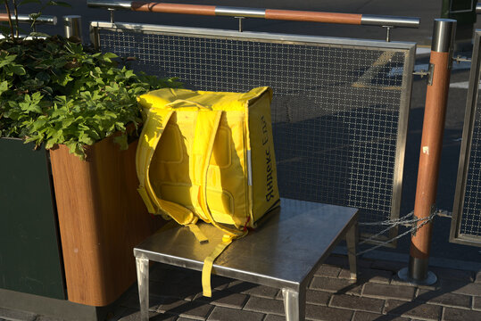 Moscow, Russia - July 20 2021: A Yellow Food Delivery Man's Refrigerator Bag Stands On A Stand Near A Fast Food Restaurant