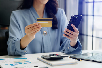Woman using smart phone for mobile payments online shopping, omni channel, sitting on table, virtual icons graphics interface screen
