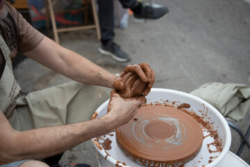 A potter makes a pot on a circle. The hands of the master create from clay. Man making ceramic pot.