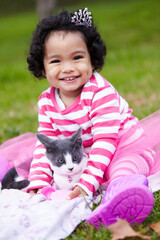 Portrait, picnic and a girl in the park with her kitten together for love, care or bonding during summer. Smile, cat or kids and a happy young child in the garden having fun with her pet animal