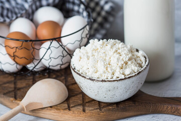 Fresh dairy products, milk, cottage cheese, eggs in stylish ceramic dishes on a gray background. The concept of natural, dietary nutrition. Useful products.