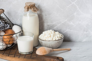Fresh dairy products, milk, cottage cheese, eggs in stylish ceramic dishes on a gray background. The concept of natural, dietary nutrition. Useful products.