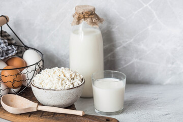 Fresh dairy products, milk, cottage cheese, eggs in stylish ceramic dishes on a gray background. The concept of natural, dietary nutrition. Useful products.