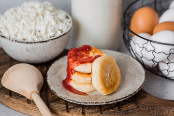 Fresh dairy products, milk, cottage cheese, cheesecakes, eggs in stylish ceramic dishes on a gray background. The concept of natural, dietary nutrition. Useful products.