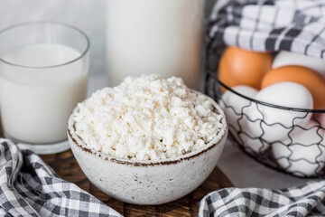 Fresh dairy products, milk, cottage cheese, eggs in stylish ceramic dishes on a gray background. The concept of natural, dietary nutrition. Useful products.