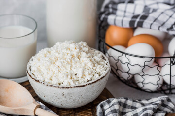 Fresh dairy products, milk, cottage cheese, eggs in stylish ceramic dishes on a gray background. The concept of natural, dietary nutrition. Useful products.