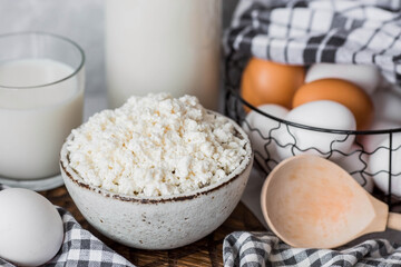 Fresh dairy products, milk, cottage cheese, eggs in stylish ceramic dishes on a gray background. The concept of natural, dietary nutrition. Useful products.