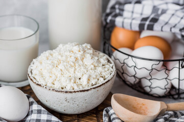 Fresh dairy products, milk, cottage cheese, eggs in stylish ceramic dishes on a gray background. The concept of natural, dietary nutrition. Useful products.