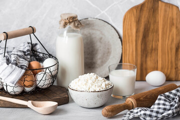 Fresh dairy products, milk, cottage cheese, eggs in stylish ceramic dishes on a gray background. The concept of natural, dietary nutrition. Useful products.
