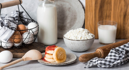 Fresh dairy products, milk, cottage cheese, cheesecakes, eggs in stylish ceramic dishes on a gray background. The concept of natural, dietary nutrition. Useful products.