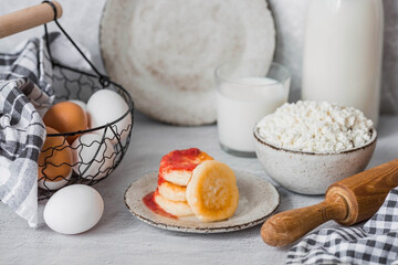 Fresh dairy products, milk, cottage cheese, cheesecakes, eggs in stylish ceramic dishes on a gray background. The concept of natural, dietary nutrition. Useful products.