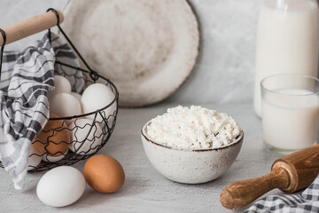 Fresh dairy products, milk, cottage cheese, eggs in stylish ceramic dishes on a gray background. The concept of natural, dietary nutrition. Useful products.