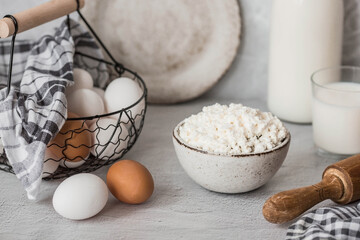 Fresh dairy products, milk, cottage cheese, eggs in stylish ceramic dishes on a gray background. The concept of natural, dietary nutrition. Useful products.