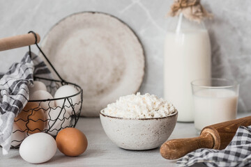 Fresh dairy products, milk, cottage cheese, eggs in stylish ceramic dishes on a gray background. The concept of natural, dietary nutrition. Useful products.