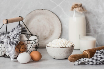 Fresh dairy products, milk, cottage cheese, eggs in stylish ceramic dishes on a gray background. The concept of natural, dietary nutrition. Useful products.