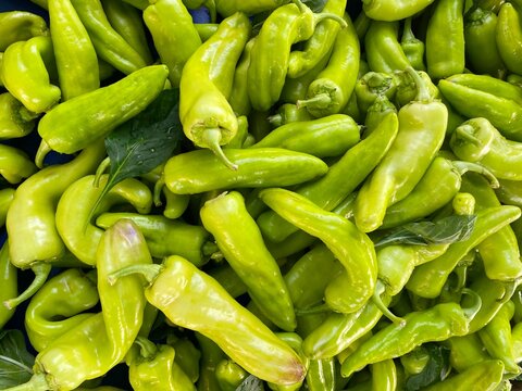 Pepper, Long Green, fresh green peppers for sale at market. Background texture of fresh green peppers closeup. Pile of peppers as background, texture. Healthy eating. Images of vegetable products