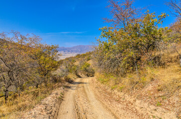 Fototapeta na wymiar dirt road in the mountains of Kungurbuka ridge near Karankul village (Tashkent region, Uzbekistan)