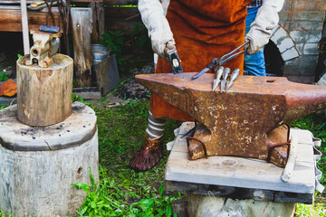 A blacksmith forges iron. Blacksmith's workshop. Blacksmith's anvil and hammer.