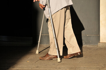 Geneva, Switzerland, Europe - elegant old man walking with crutches
