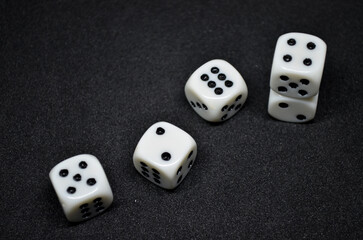 White dice are small, cube-shaped gaming accessories, on black background, They have blackpips on each face, are commonly used in various tabletop games.