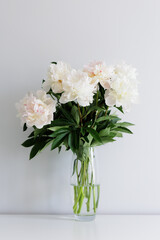 Close up of beautiful fresh white peonies bouquet in vase
