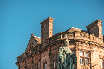 Fototapeta na wymiar Edinburgh a bronze statue of a male figure standing in front of an architectural structure
