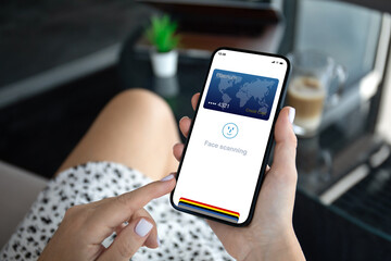 female hands hold phone with face scanning id on screen