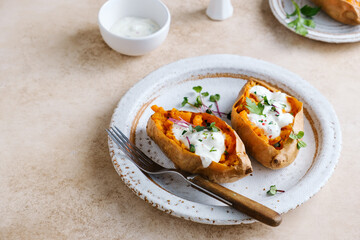 Whole baked sweet potatoes with spices, herbs and sour cream. Selective focus. Healthy diet food
