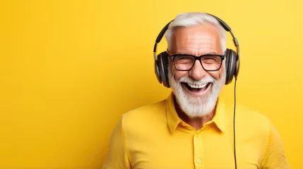 Fotobehang Muziekwinkel senior man smiling in headphones listening to music yellow background banner