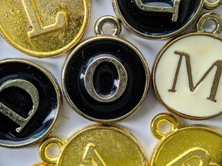Black and gold initial 'O' pendant in the middle of several letters