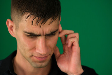 emotions of a handsome man guy on a green background chromakey close-up dark hair young man. My...