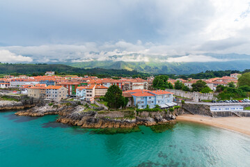 Fototapeta na wymiar Sablon beach and the city of Llanes with the Cantabrian mountain range in the background, Asturias.