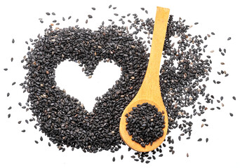Black cumin seeds arranged in shape of heart isolated on white background. Top view.