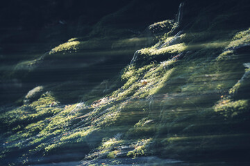 Abstract rock formation with green moss creative dynamic and striking light