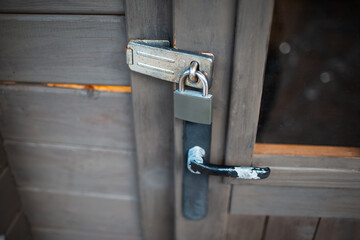 Close-up of exterior padlock and old handle of wooden door.