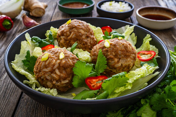 Lion's head meatballs - steamed big meatballs served with vegetables on wooden background 