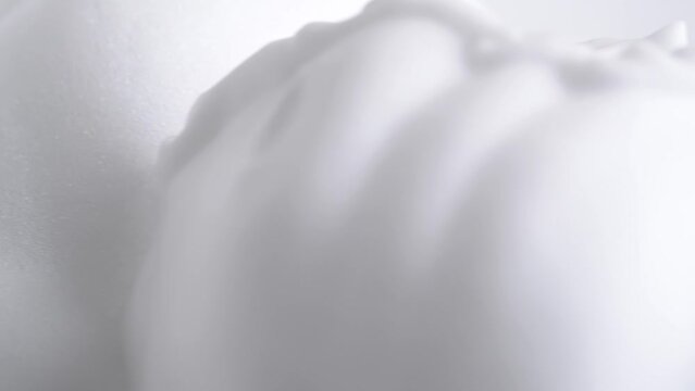 Hair foam mousse, macro. Beauty background. Close up of white cloud of hair mousse or shaving foam. Soap suds