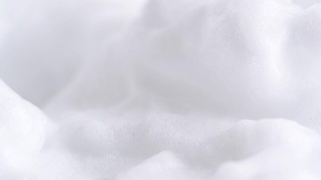 Hair foam mousse, macro. Beauty background. Close up of white cloud of hair mousse or shaving foam. Soap suds