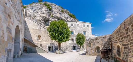 Fort l'Écluse, France - 09 01 2021: View of the upper fort courtyard with trees and the rock...