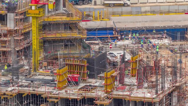 Large construction site with working cranes timelapse. Top aerial close up view of big development of residential and office district with many workers in Business bay, Dubai