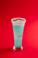 blue cocktail with coconut shavings on a bright background