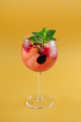 Pink cocktail with raspberries and blackberries on a bright background
