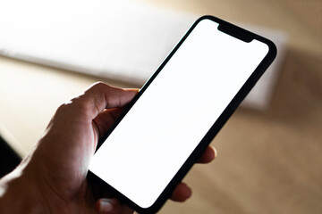 Close-up of a businessman hand holding a smartphone white screen