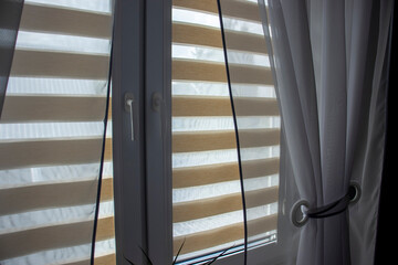  Cozy room interior with day-night blinds on the window.
